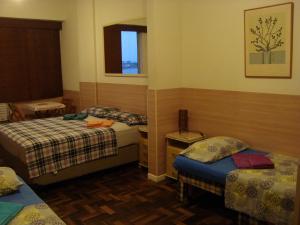 Cette chambre comprend 2 lits et une fenêtre. dans l'établissement Alex Rio Flats Studio Beach View, à Rio de Janeiro