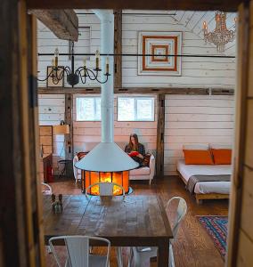 a woman sitting in a living room with a fireplace at the barn at gallatin farmstead in Red Hook