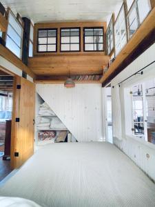 an attic room with a large bed and windows at the barn at gallatin farmstead in Red Hook