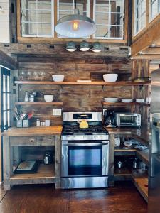 a kitchen with a stove and wooden walls and cabinets at the barn at gallatin farmstead in Red Hook