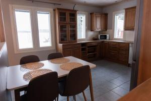 a kitchen with a table and chairs and windows at Villa Ylämylly in Joensuu