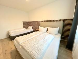 - une chambre avec 2 lits et des draps blancs dans l'établissement Apartment Leverkusen, à Leverkusen