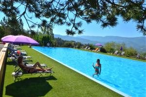 una donna e un bambino che giocano in piscina di Camping les Hauts de Rosans a Rosans