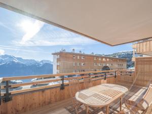 a balcony with a table and chairs and mountains at Appartement lumineux avec parking, proche des pistes à Alpe d'Huez - FR-1-645-62 in LʼHuez