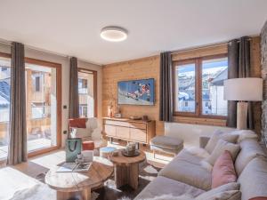 Una sala de estar con un sofá y un televisor. en Charmant appartement 3 pièces proche des pistes avec balcon, cuisine équipée et garage à l'Alpe d'Huez. - FR-1-645-52, en LʼHuez
