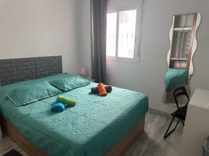 ein Schlafzimmer mit einem Bett mit zwei Spielzeugen darauf in der Unterkunft Torremolinos habitaciones privada en apartamentos compartidos in Torremolinos