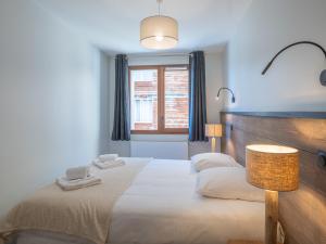 a bedroom with two beds and a window at Appartement Alpe d'Huez 4 adultes+2 enfants avec parking et WiFi - FR-1-645-66 in LʼHuez