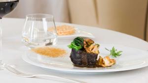 une assiette de nourriture sur une table avec un verre de vin dans l'établissement Le Sénéchal, à Sauveterre-de-Rouergue