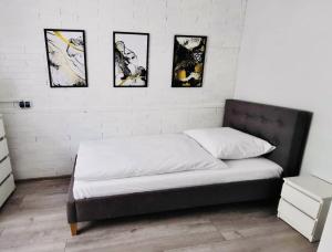 1 cama en una habitación con 4 cuadros en la pared en Apartment, en Ryn