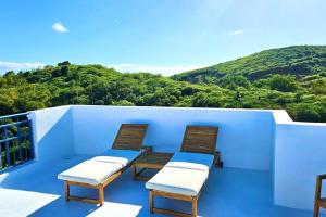balcone con 3 sedie e vista sulle montagne di Private Penthouse Paradise a Ceiba