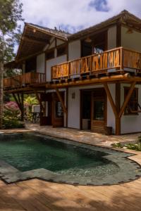 ein Haus mit einem Balkon und einem Pool in der Unterkunft Village Boutique La Dolce Vita in Trancoso