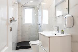 a white bathroom with a toilet and a sink at Romantic Jacuzzi Studio in Cluj-Napoca