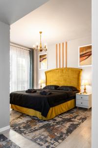 ein Schlafzimmer mit einem großen Bett mit einem gelben Kopfteil in der Unterkunft Romantic Jacuzzi Studio in Cluj-Napoca