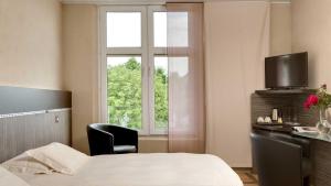 une chambre d'hôtel avec un lit et une fenêtre dans l'établissement Le Sénéchal, à Sauveterre-de-Rouergue