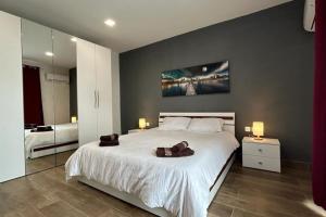 Charming 3-Bed Retreat with Small Pool في سانت جوليانز: غرفة نوم بسرير كبير وعليها حقيبتان بنيتان