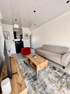 een woonkamer met een bank en een tafel bij Fiore Apartments. in Kaapstad