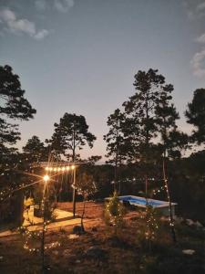 einen beleuchteten Bereich mit einem Zelt und Bäumen in der Unterkunft Casa Tres Vientos in Guasculile