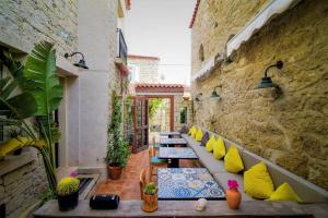 a row of benches with yellow and blue pillows on a patio at Micel Otel Alacati in Alaçatı