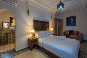 a bedroom with a large white bed and a couch at Dar Bleu main in Chefchaouene