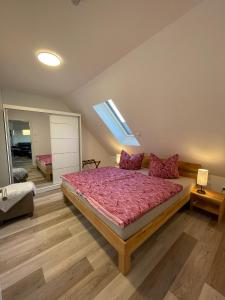 um quarto com uma cama com um edredão rosa em Ferienhaus Helfert FeWo2 em Niemtsch
