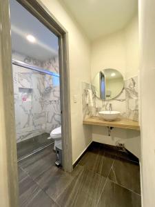 a bathroom with a sink and a toilet and a mirror at Capital Suites in Chilpancingo 