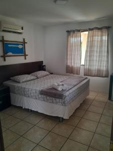 1 dormitorio con 1 cama con 2 toallas en Suítes cambucá en Parati