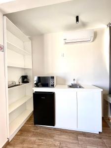 uma cozinha com armários brancos e um frigorífico preto em Capital Suites em Chilpancingo 