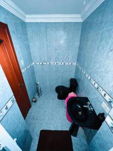 a blue bathroom with a toilet and a sink at Departamento en el Centro de Loja in Loja