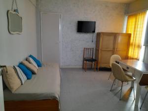 a bedroom with a bed and a desk and a table at Depto Miramar in Miramar +2 photos