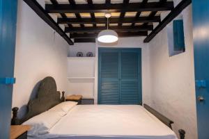 a bedroom with a bed with a blue door at GINVA - Casa con encanto en pleno centro in Vejer de la Frontera