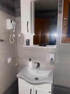 ein Badezimmer mit einem weißen Waschbecken und einem Spiegel in der Unterkunft Drinka in Ljubovija