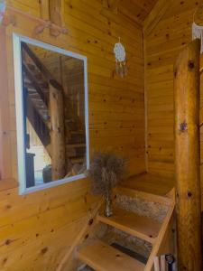 a wooden cabin with a window and stairs in it at Drinka in Ljubovija