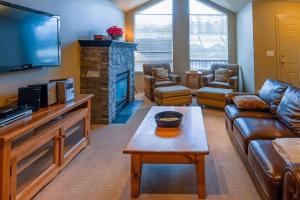 ein Wohnzimmer mit einem Sofa und einem Kamin in der Unterkunft Thunder Ridge Chalet by Fernie Lodging Company in Fernie