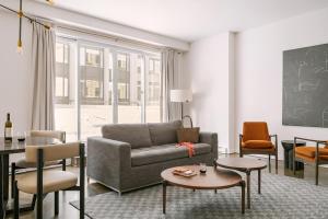 a living room with a couch and a table and chairs at Sonder Penny Lane in Montreal