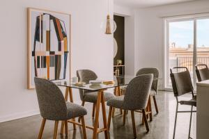 uma sala de jantar com uma mesa de vidro e cadeiras em Sonder Penny Lane em Montreal