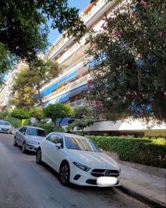 ein weißes Auto, das am Straßenrand geparkt ist in der Unterkunft Sea View Studio in Athen