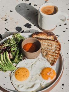 a plate of eggs and toast and a cup of coffee at Residencia Tropical Don Bonito in Sayulita