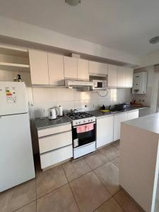 布蘭卡港的住宿－Departamento céntrico completo，厨房配有白色橱柜、炉灶和冰箱。
