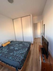 een slaapkamer met een bed en een flatscreen-tv bij Departamento céntrico completo in Bahía Blanca