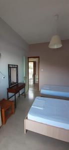 1 Schlafzimmer mit 2 Betten, einem Tisch und einem Spiegel in der Unterkunft Theasea in Parga