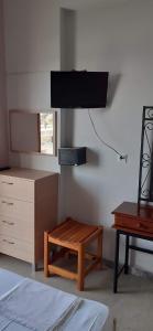 sypialnia z telewizorem, stołem i krzesłem w obiekcie Theasea w mieście Parga