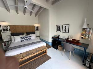 a bedroom with a large bed and a desk at Hotel El Ciruelo, Tepoztlán in Tepoztlán