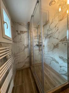 uma cabina de duche ao nível do chão numa casa de banho com paredes em mármore em Gîte au Giessen - Loft em Biesheim