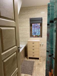 a bathroom with a sink and a mirror and a door at Varázskuckó Apartman in Sümeg