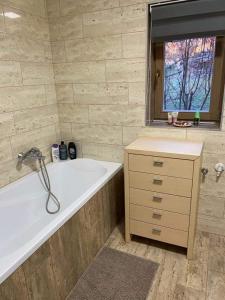 a bathroom with a bath tub and a window at Varázskuckó Apartman in Sümeg