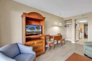 een woonkamer met een televisie en een eetkamer bij Oceanfront Boardwalk Condo w Private Balcony and Beach in Myrtle Beach