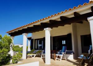 Casa con patio con sillas y techo en Casa Sa Playa - Astbury Formentera, en Es Arenals