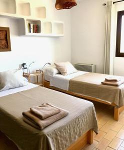 Dos camas en una habitación con toallas encima. en Casa Sa Playa - Astbury Formentera, en Es Arenals