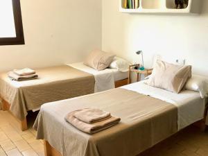 Dos camas en una habitación con toallas encima. en Casa Sa Playa - Astbury Formentera, en Es Arenals