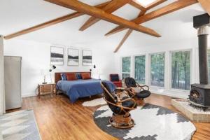 uma sala de estar com uma cama e uma lareira em Modern Wooded Oasis with Hot Tub, WiFi, Deck, Grill & Dome! em Hedgesville